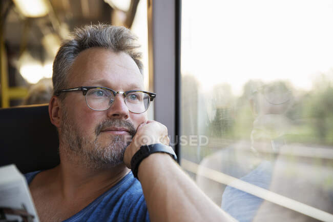 Взрослый мужчина у окна поезда — стоковое фото