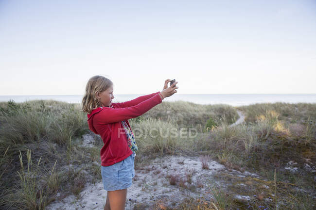 Menina tomando selfie em dunas de areia — Fotografia de Stock
