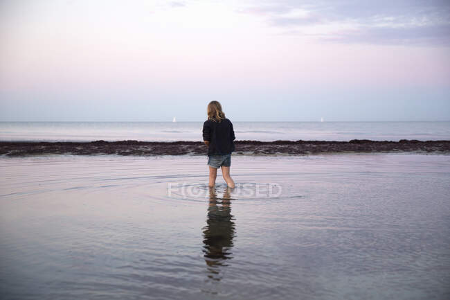 Дівчинка пливе морем на заході сонця. — стокове фото