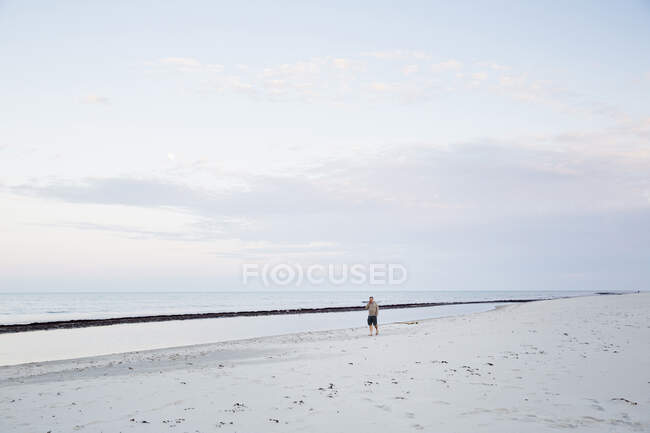 Человек, идущий по пляжу — стоковое фото
