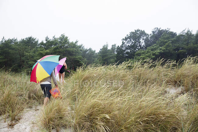 Family walking on sand dunes — Stock Photo