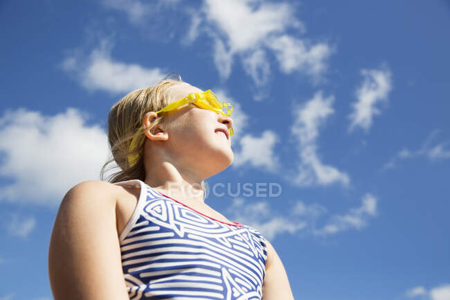 Girl in goggles under clouds — Stockfoto