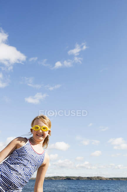 Smiling girl in goggles and swimsuit by sea — Foto stock