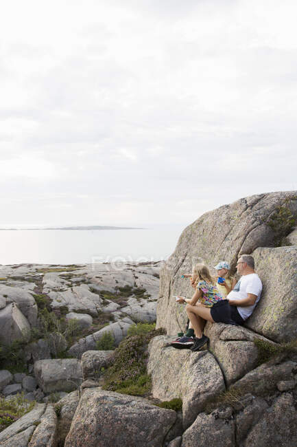 Family on rocks by sea — Foto stock