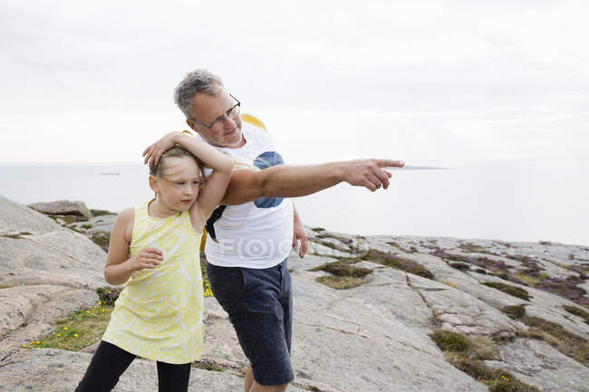 Vater und Tochter blicken an der Küste in die Ferne — Stockfoto