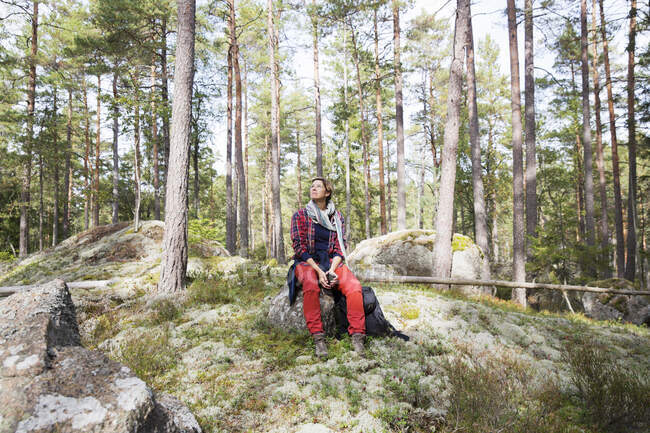 Donna seduta sulla roccia nella foresta — Foto stock