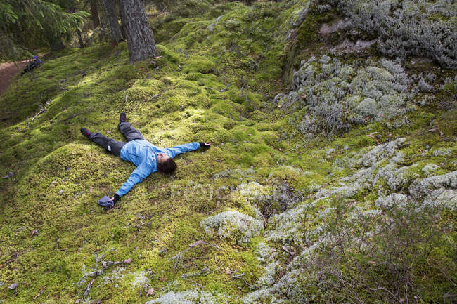 Woman lying in moss in forest — Foto stock