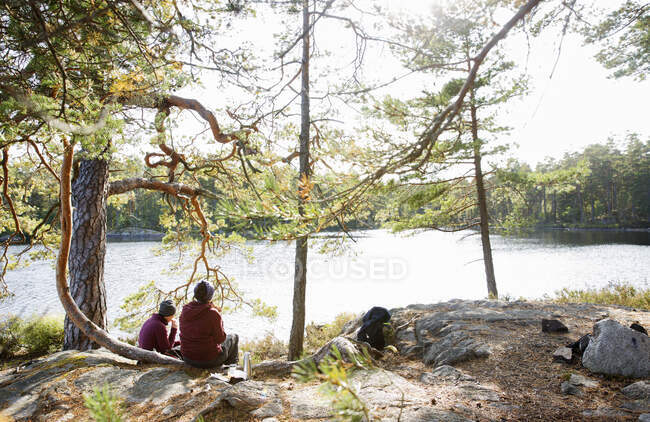 Mujeres sentadas junto al lago - foto de stock