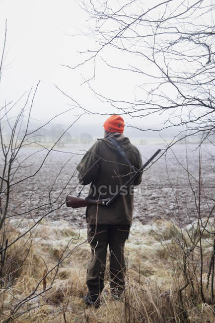 Hunter standing in the field — Photo de stock