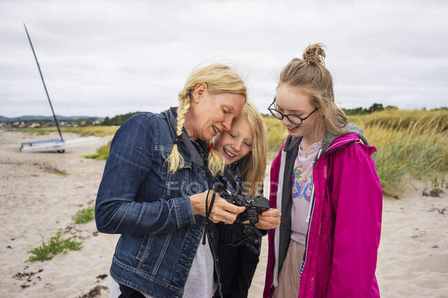 Женщина показывает дочерей на камеру — стоковое фото