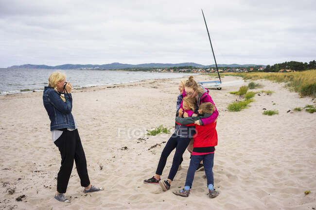 Mulher fotografando seus filhos na praia — Fotografia de Stock