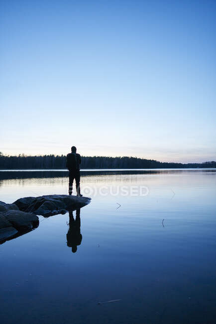 Silhueta de homem por mar ao pôr do sol em Bjorno, Suécia — Fotografia de Stock