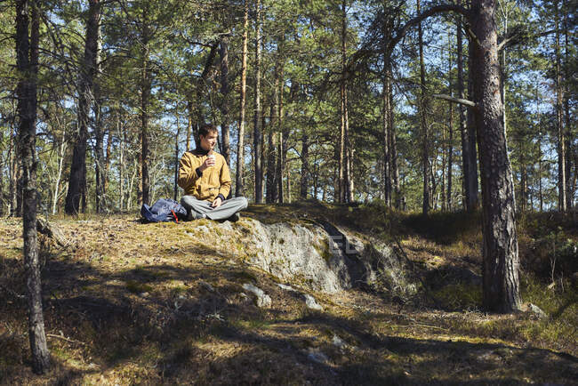 Man holding cup in forest in Djurgarden, Sweden — Stockfoto