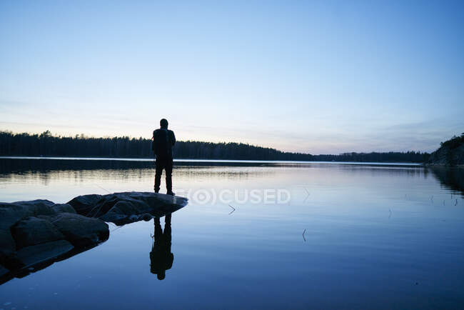Silhouette de l'homme par la mer au coucher du soleil à Bjorno, Suède — Photo de stock