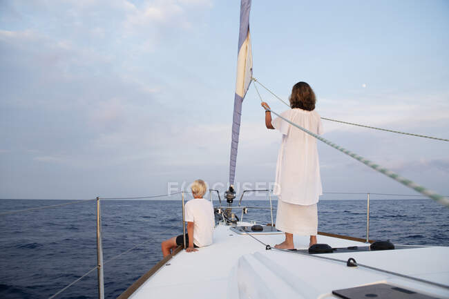 Жінка і підліток хлопчик на вітрильному човні в морі — стокове фото