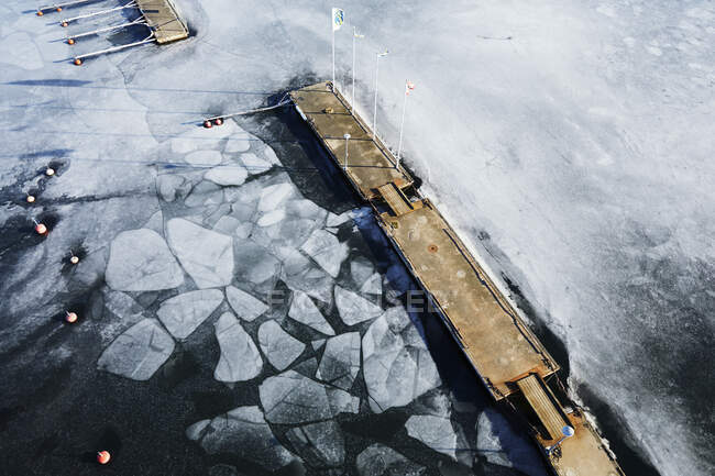 Pier in frozen harbour with ice — Fotografia de Stock