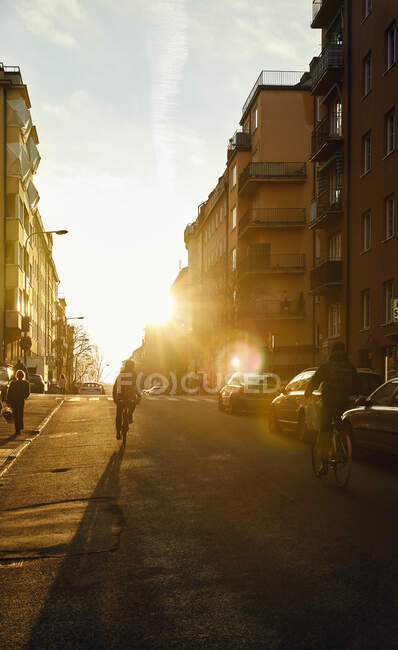 Ciclistas na rua durante o pôr do sol — Fotografia de Stock