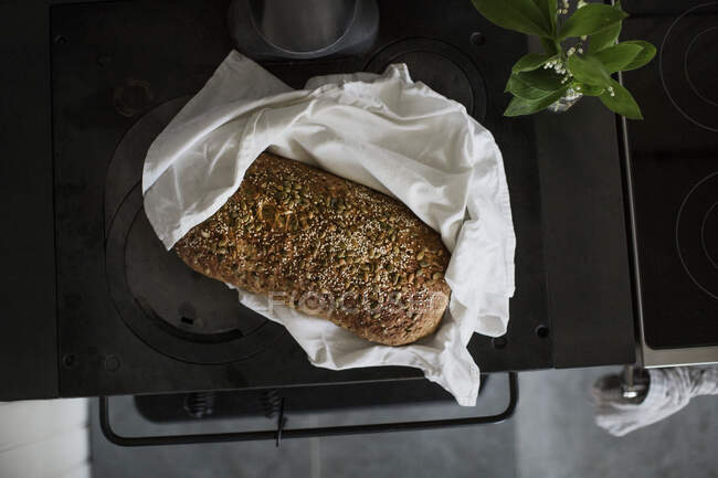 Sourdough bread on stove and lilly — Stockfoto