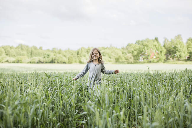 Girl in gray dress walking in field — Photo de stock