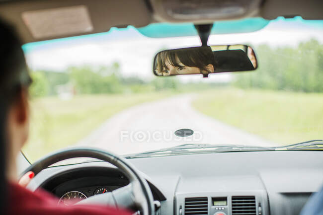 Frau beim Autofahren im Rückspiegel gesehen — Stockfoto
