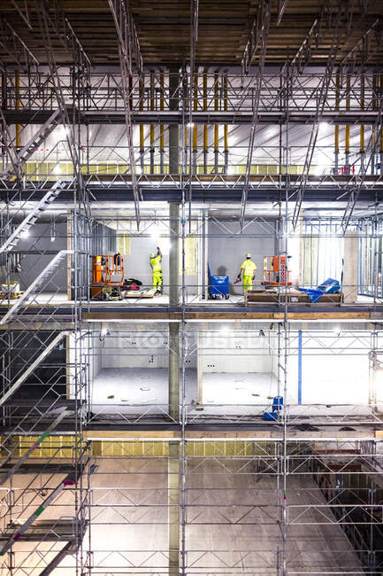 Workers on scaffolding at construction site — Stock Photo