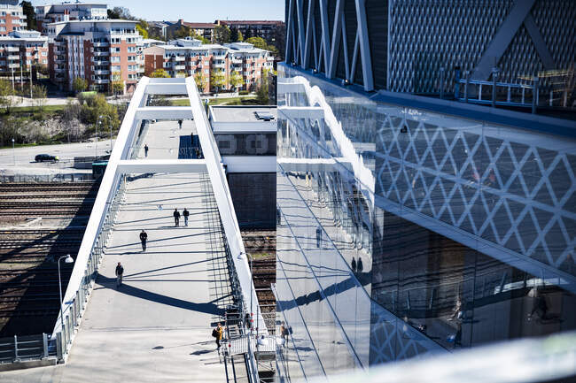 Brücke über Bahngleise durch Hochhaus — Stockfoto