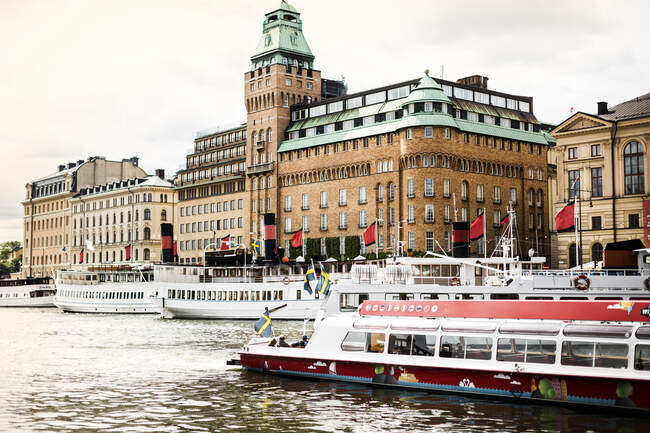 Barcos por edificios en Estocolmo, Suecia - foto de stock