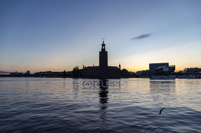 Silhouette des bâtiments par la mer au coucher du soleil à Stockholm, Suède — Photo de stock