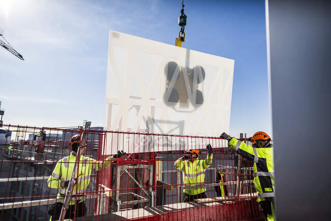 Рабочие устанавливают окна на строительной площадке — стоковое фото