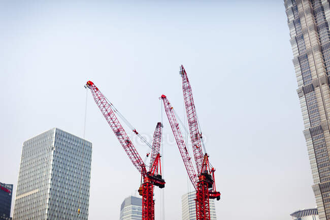 Low angle view of cranes and skyscrapers — Foto stock