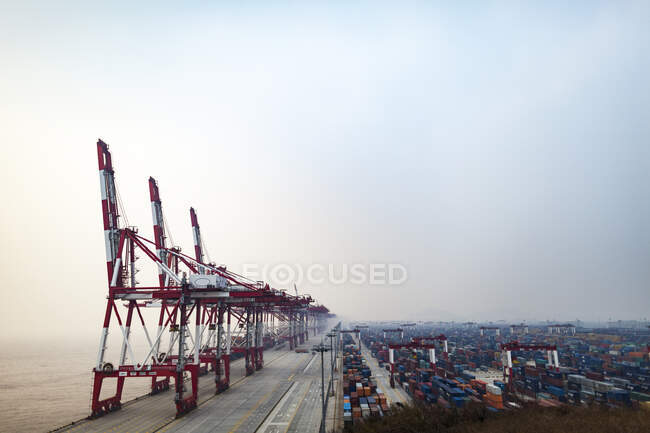 Cranes and shipping containers at port — Photo de stock