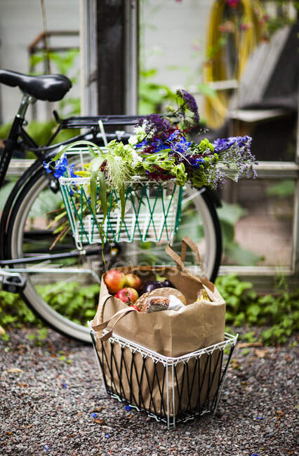 Продукты питания в корзине и велосипеде — стоковое фото