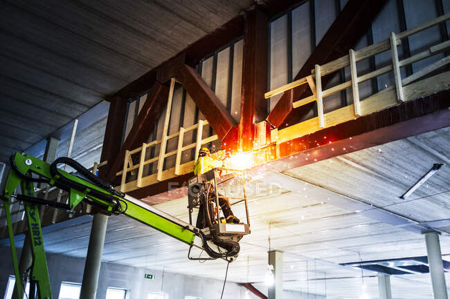 Construction worker welding from crane — Fotografia de Stock
