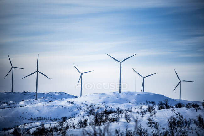 Wind turbine on snowy hills — Photo de stock