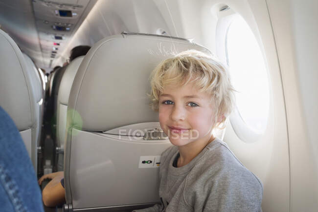 Young boy sitting in airplane — Photo de stock