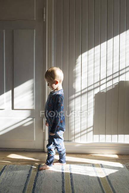 Boy walking barefoot in corridor — Stockfoto