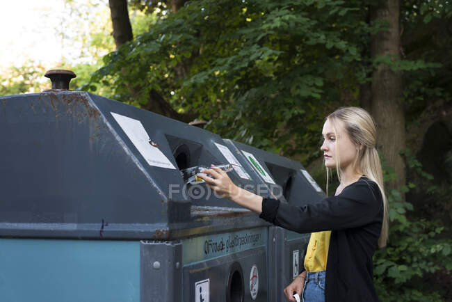 Young woman recycling glass bottle — Fotografia de Stock
