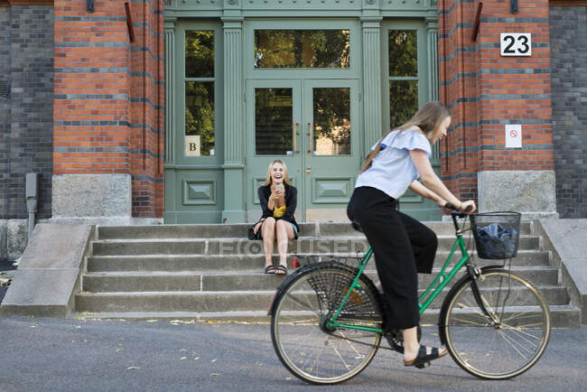 Sisters with bicycle in city — Stock Photo
