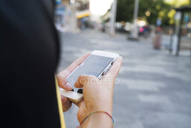 Hands of young woman holding smart phone — Foto stock