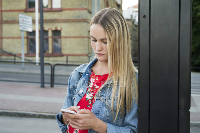 Молода жінка зі смартфоном у місті — стокове фото