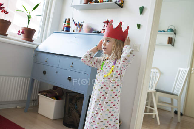 Девушка в сердце шаблон платье и красная бумажная корона — стоковое фото