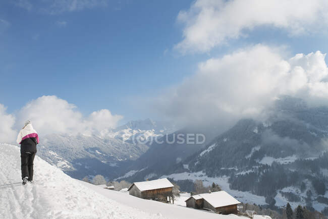 Chica caminando en la nieve en la montaña - foto de stock