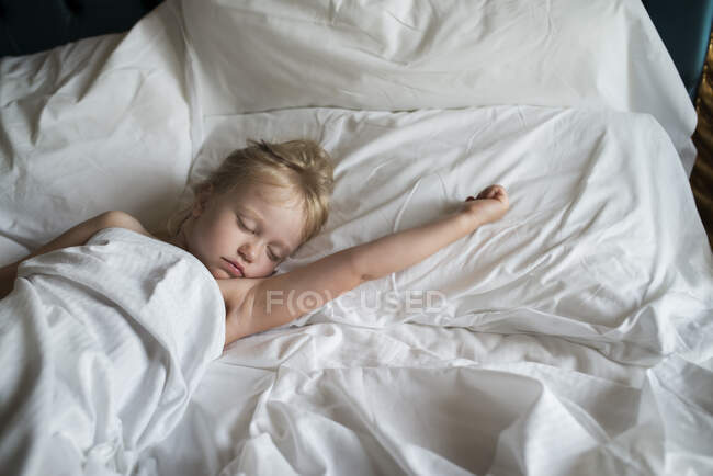 Girl sleeping in bed with white linen — Fotografia de Stock