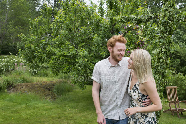 Усміхнена молода пара в саду — стокове фото