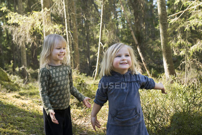 Meninas sorridentes na floresta ensolarada — Fotografia de Stock