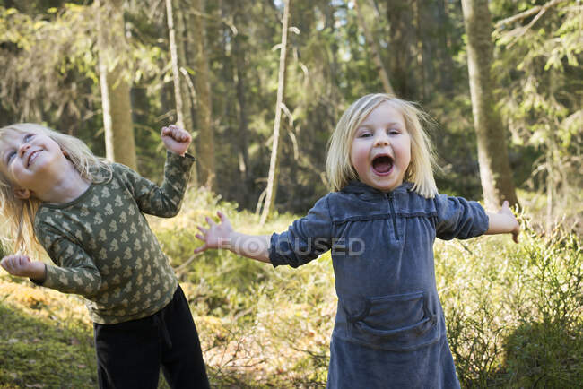 Усміхнені дівчата в сонячному лісі. — стокове фото
