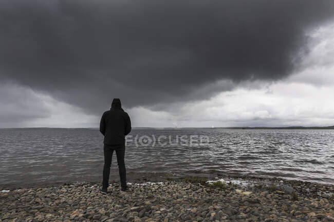 Man standing on shore of Lake Glan, Sweden — Photo de stock