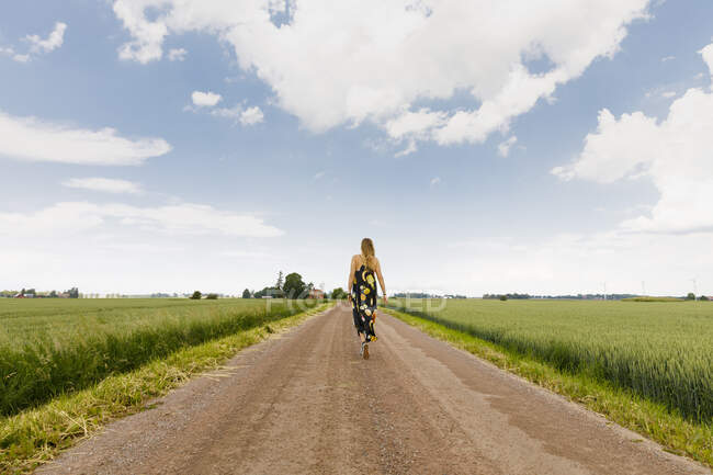 Donna che cammina sulla strada rurale — Foto stock