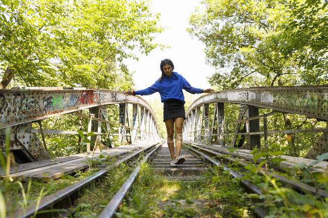 Young woman walking on abandoned railway tracks — Foto stock