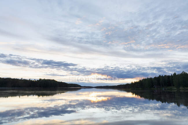 Хмари, відображені в озері на заході сонця — стокове фото